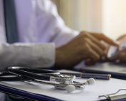 Doctor calculating numbers with clipboard and calculator