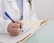 Doctor documenting in folder